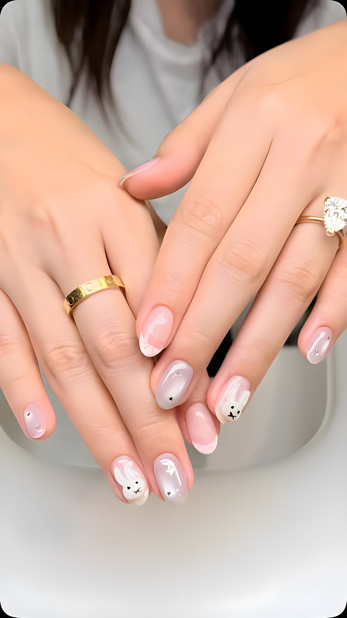 Milky nude almond nails with tiny bow and flower charms